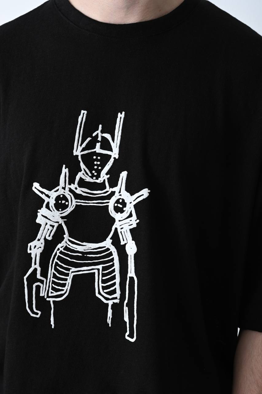 Siyah renkli, yüksek gramajlı pamuk kumaştan üretilmiş unisex oversize tişört; ön yüzünde modern robot baskısı bulunan, teknolojik ve şehir stiline uygun kısa kollu rahat bir model.
