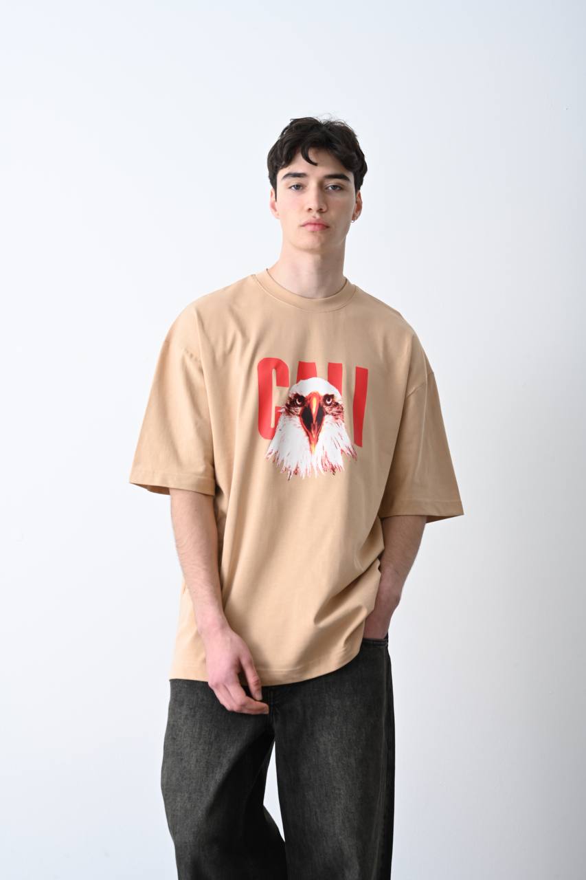 Camel oversize tişört üzerindeki kartal baskısı, özgün ve güçlü bir görünüm sunarak unisex kullanıcılar için şık bir seçim olur.