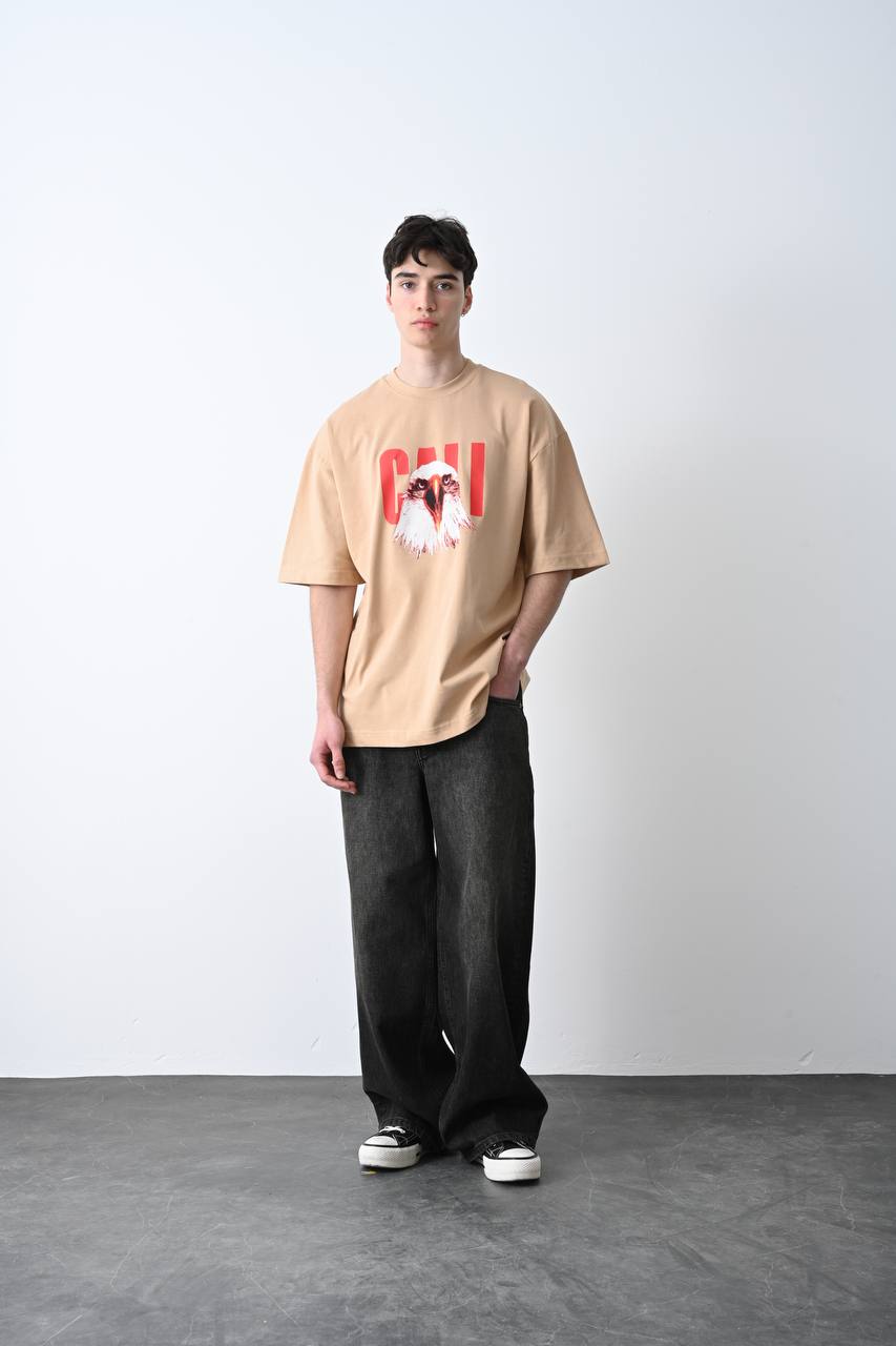 Camel oversize tişört üzerindeki kartal baskısı, özgün ve güçlü bir görünüm sunarak unisex kullanıcılar için şık bir seçim olur.