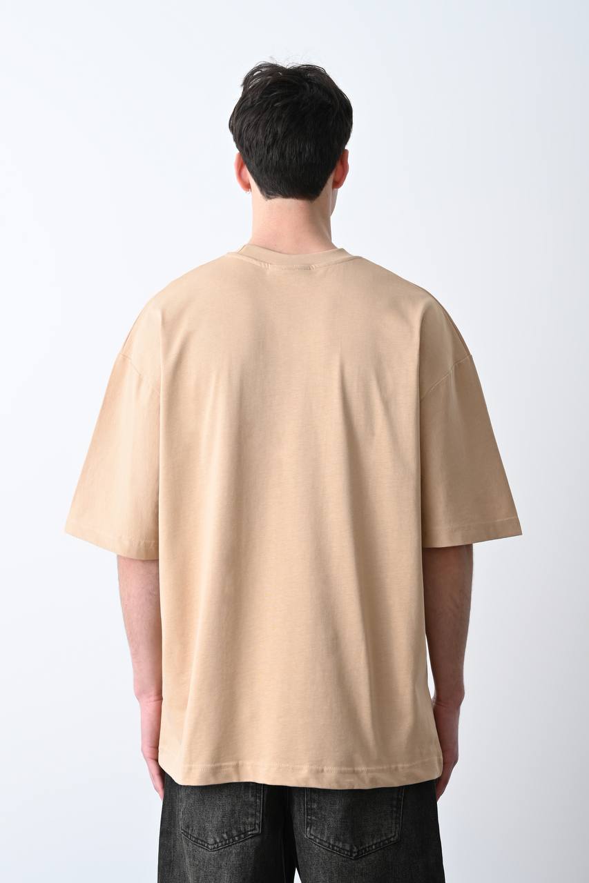 Camel oversize tişört üzerindeki kartal baskısı, özgün ve güçlü bir görünüm sunarak unisex kullanıcılar için şık bir seçim olur.